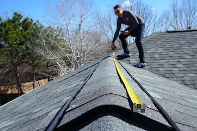 Man measures roof to make sure a new metal roof will fit